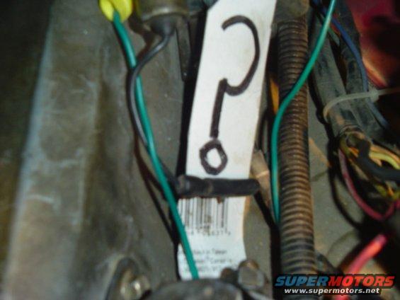 Close-up of a vehicle's wiring harness with a tag marked with a question mark