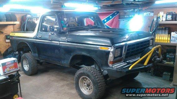 Black 1978 Ford Bronco with yellow stripe on the hardtop, lifted with off-road tires and a yellow bull bar on the front bumper