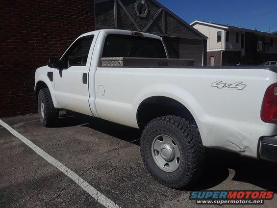 White Ford F-350 pickup truck parked, side view. Has 4x4 decal on fender