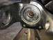 1989 Ford Bronco - Close-up of a worn automotive suspension part, likely a knuckle or spindle, showing internal wear and grease residue.