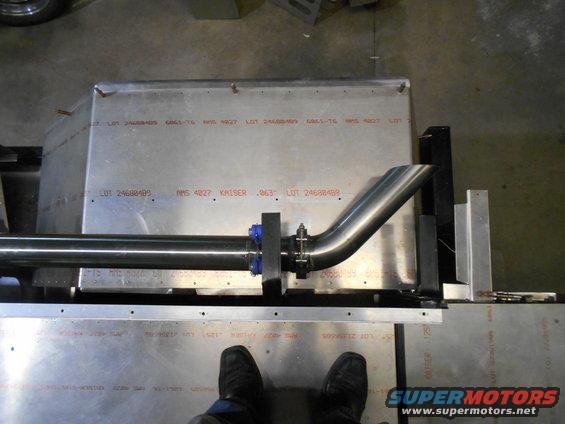 Exhaust pipe attached to metal sheeting with visible lot numbers and text