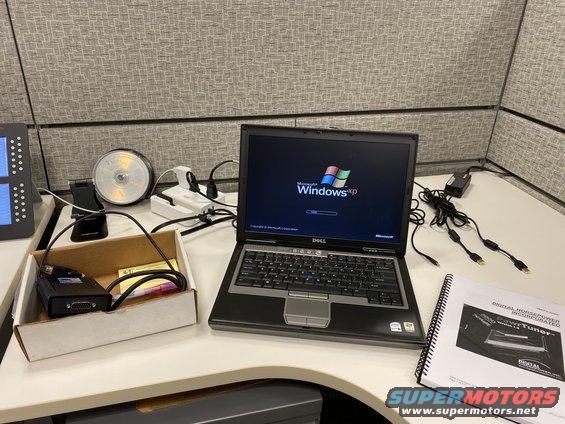 Laptop with Windows XP, diagnostic tool, and manual on a desk