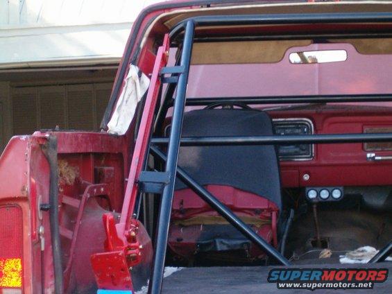 1979 Ford Bronco interior showing roll cage, red dashboard, and seats