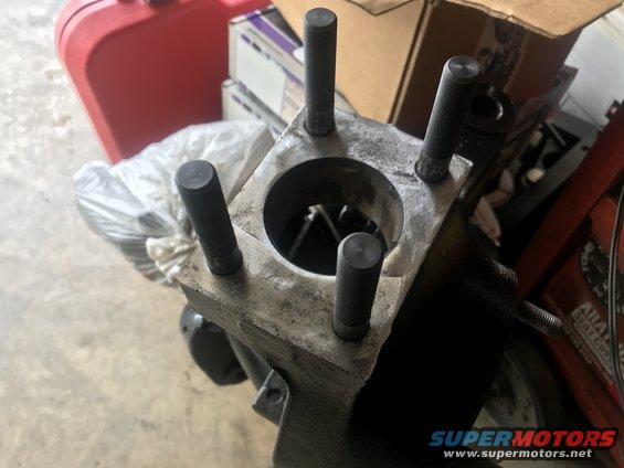 Engine cylinder block with four studs protruding from the top