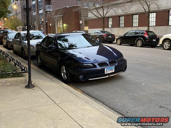 Dark blue 2000 Pontiac Grand Prix coupe parked curbside, front 3/4 view. License plate reads BLUTRBQ