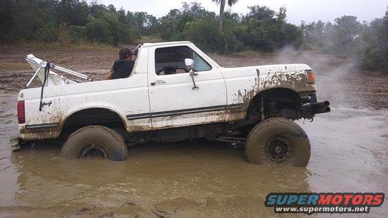 White Ford Bronco stuck in mud, 1987 model