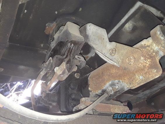 Underside view of rusty suspension parts and frame components