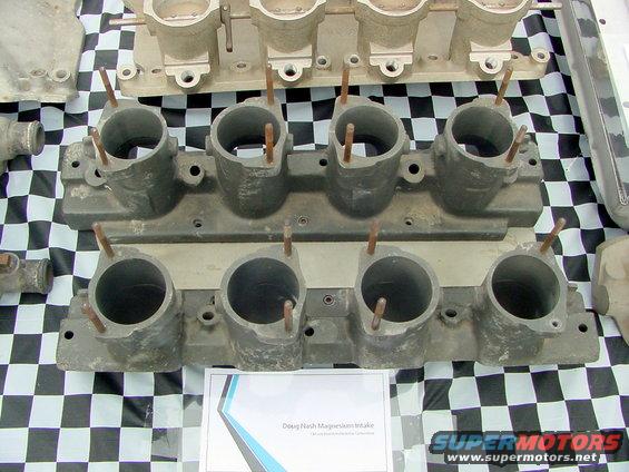 Two aluminum intake manifolds with multiple ports, one labeled 'Doug Nash Magnesium Intake'