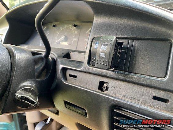 Dashboard with steering wheel, gauges, and aftermarket switches