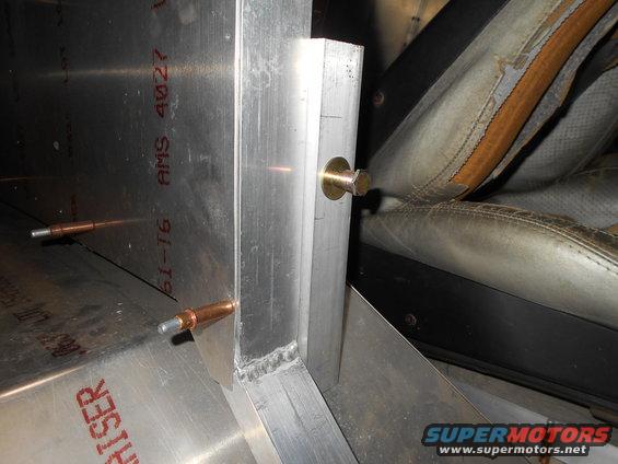 Interior view of a vehicle seat and metal bracing with visible text