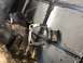 1992 Jeep Wrangler - A metal part is being welded, held by a gloved hand over a metal grid.