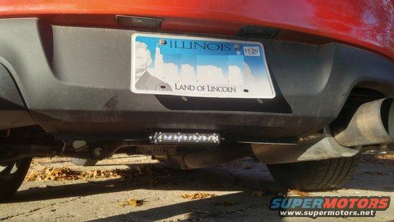 Rear bumper of a car with an Illinois license plate and a light bar mounted underneath