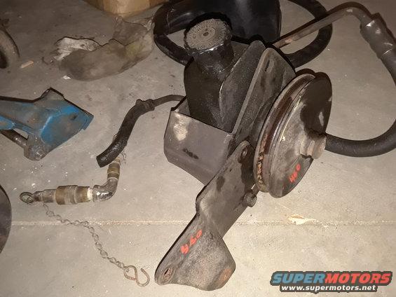 Power steering pump assembly with pulley and hoses, some red markings on bracket