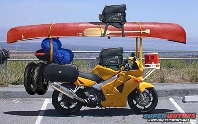 Yellow motorcycle carrying a red canoe and camping gear
