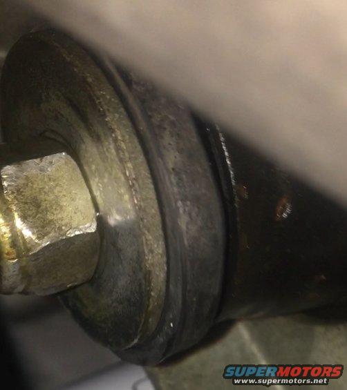Close-up of bolt and metal component with Supermotors.net logo