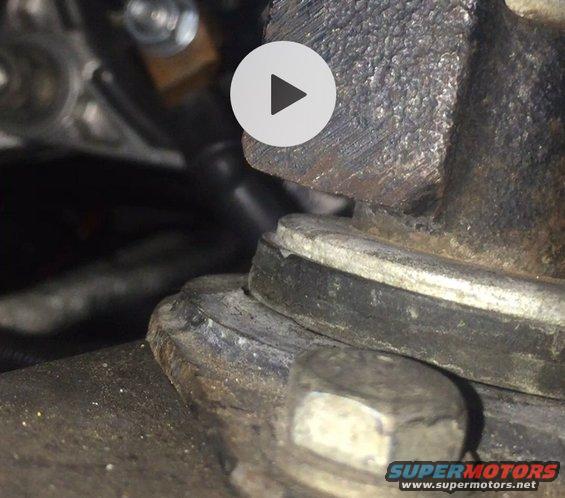 Close-up of a metal engine component with a bolt and washer