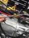 1992 Jeep Wrangler - A hand holds a braided hose connected to a brass valve assembly on an engine.
