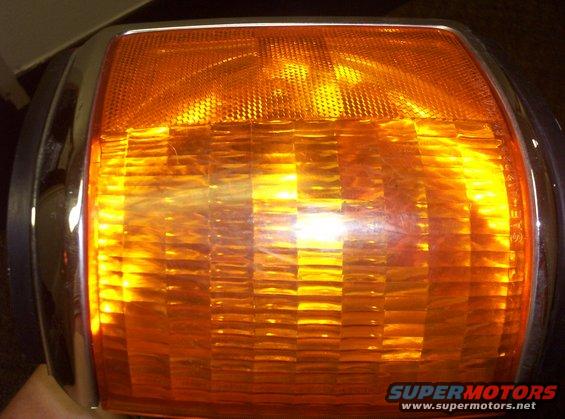Orange turn signal assembly with chrome trim and textured lens
