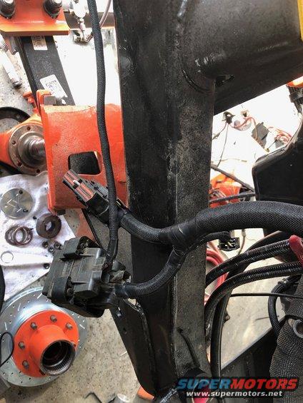 close-up of vehicle wiring harness and brake rotor with orange hub