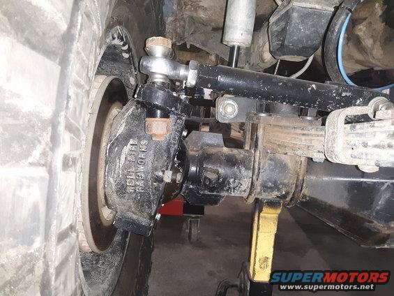 Close-up of a vehicle's front suspension with "HELL FIRE FABWORKS" visible on a component