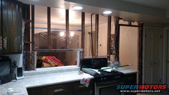 Kitchen under renovation with exposed studs, countertop, and stove