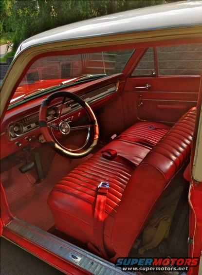Red vinyl bench seat and dashboard of a classic car
