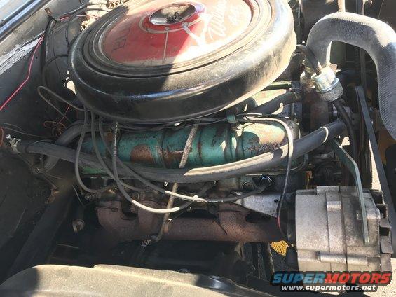 Engine bay with a large red and black air cleaner, green engine block, and alternator
