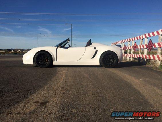 White convertible sports car side view with black wheels