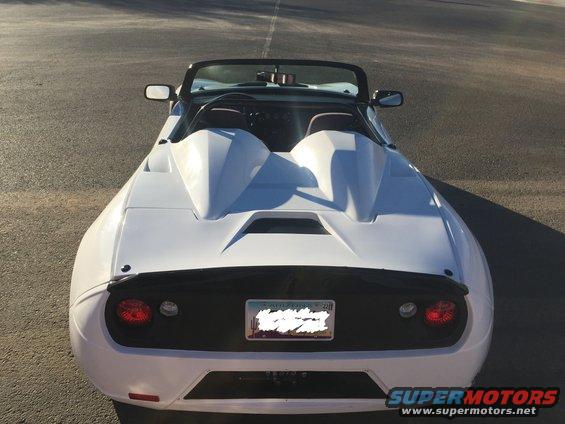 White convertible sports car rear view with dual humps behind seats