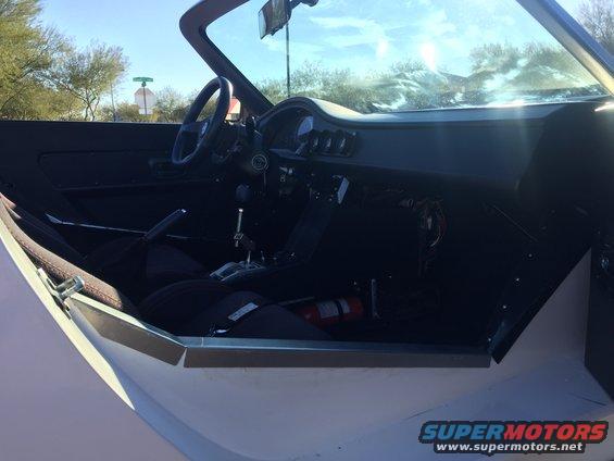 Interior view of a custom sports car with racing seats and a fire extinguisher