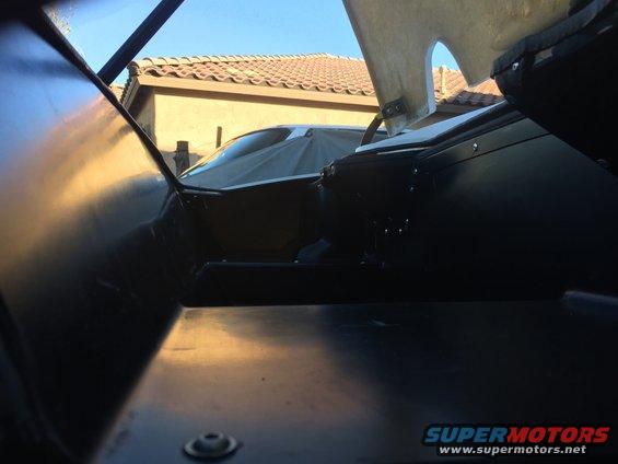 View from inside a car looking out at another car covered with a tarp