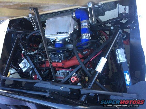 Engine bay with intercooler, blue hoses, and red exhaust manifold