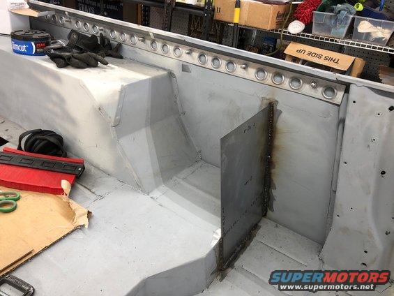 Interior of a vehicle undergoing repair, showing metalwork and tools