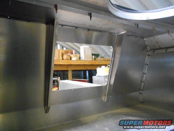 Interior of a metal structure with shelves and boxes visible through an opening