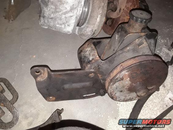 Power steering pump with pulley and reservoir cap. Some rust visible