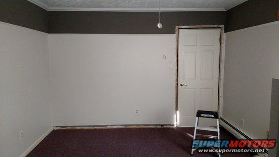Interior of an empty room with white walls and dark carpet