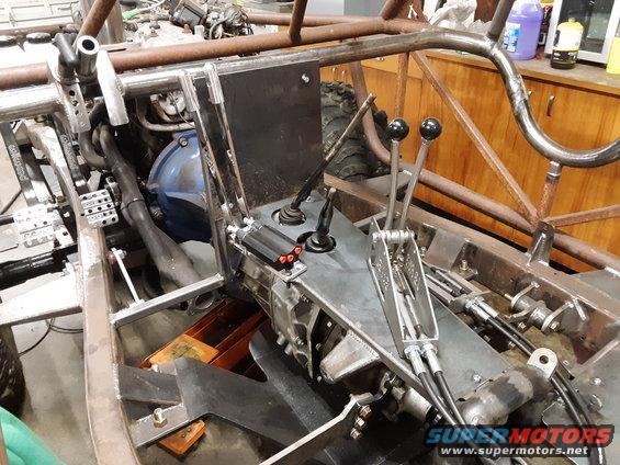 Custom off-road vehicle interior, bare metal frame, dual shifters, exposed transmission and engine components