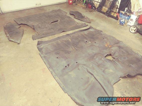 Car floor mats laid out on a concrete floor