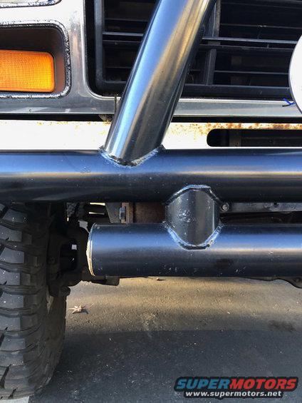 Front of a Ford Bronco with a roll cage, custom bumper, and orange turn signal