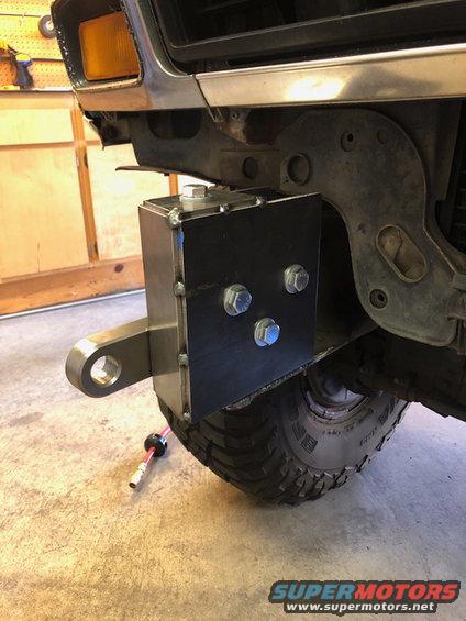 Aftermarket bumper mount with tow hitch receiver attached to a 1980s Ford Bronco front end