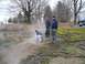 1979 Ford Bronco - A group of people are gathered in a misty outdoor environment, with one person examining the ground.