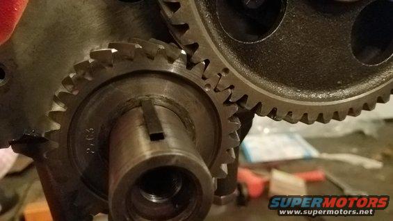 Close-up of two meshing engine gears, one with part number '2.03' visible