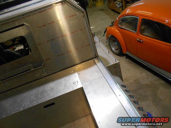Metal structure with visible text and an orange VW Beetle in the background.
