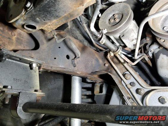 The smog pump is gutted - it spins freely. The transmission cooler hose appears to have been replaced with the wrong type of hose. The RFI strap has been bolted to the frame. All the lift hardware seems to be tight.
