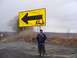 1979 Ford Bronco - A man poses for a photo next to a large yellow directional sign on an overcast day.