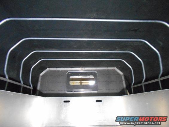 Interior of a vehicle cargo area with metal walls and ceiling supports.
