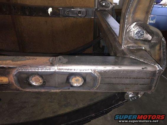 Welded metal frame with bolts and leaf springs, close-up view