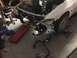 1993 Mercury Tracer - The front end of a white car is disassembled, revealing the engine and surrounding components, with exhaust pipes and tools scattered on th…
