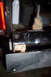 1995 Ford Bronco - Rusted jack mechanism on a vehicle bumper, with wood block support visible.