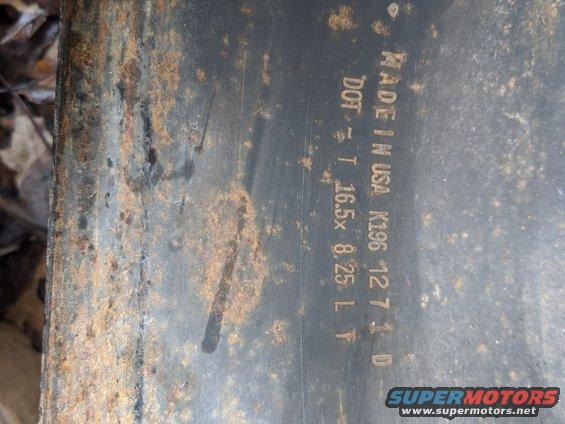 Rusted metal part with text "MADE IN USA K196 12 7 1 D DOT T 16.5x 8.25 L F" and "SUPERMOTORS www.supermotors.net"